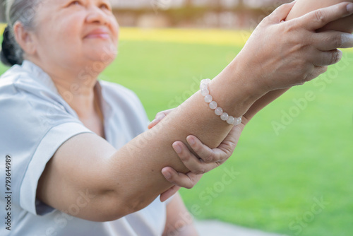 Cropped view of elderly woman with care helper support and takecare for a walk at park. photo