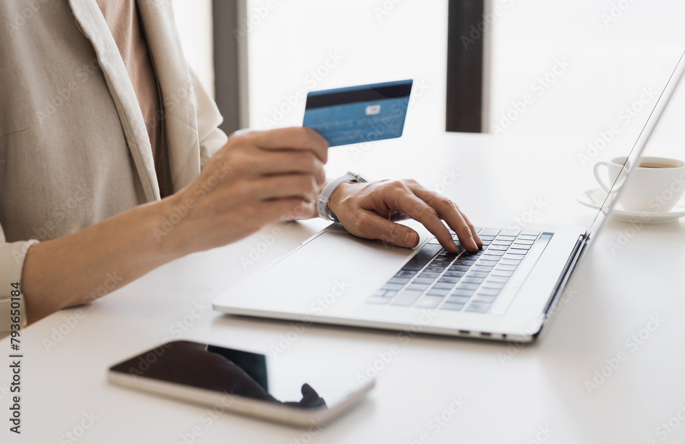 Woman hands using laptop computer and holding credit card at office, young girl or entrepreneur working at home, online shopping, e-commerce, internet banking, finance and freelance concept Woman hands using laptop computer and holding credit card at office, young girl or entrepreneur working at home, online shopping, e-commerce, internet banking, finance and freelance concept