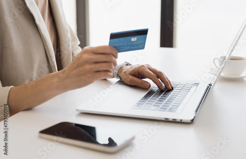 Woman hands using laptop computer and holding credit card at office, young girl or entrepreneur working at home, online shopping, e-commerce, internet banking, finance and freelance concept
