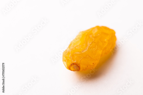 macro photograph of one raisin on a white background, side view