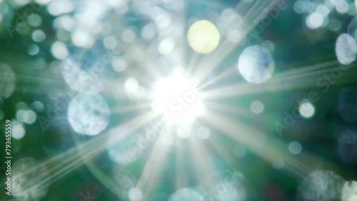 夏の太陽の暑く強い日差し　木々の葉から差し込むさわやかな木漏れ日の光とキラキラの輝く明るい丸ボケと光芒　アウトドア・夏休み・日焼け・バカンス・旅行・洗濯のイメージ背景　
