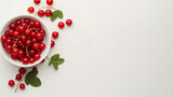 Red currants in a bowl on a white table aerial view space on the right