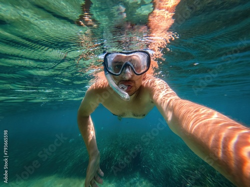 Self view of man diving on clear water photo