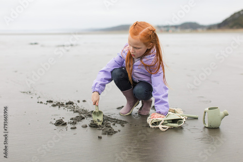 Redhead girl playing on overcast beach photo