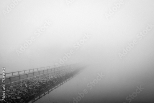 Causeway disappears into mist along coast, Stonington, Maine photo
