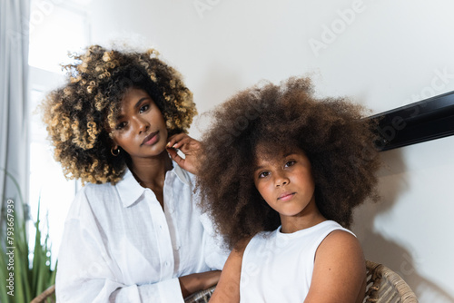 Portrait of mother and daughter looking at camera