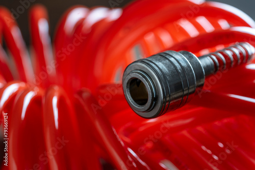 An orange air hose with an hose coupling , closeup. Detail of air compressor hose and pistol