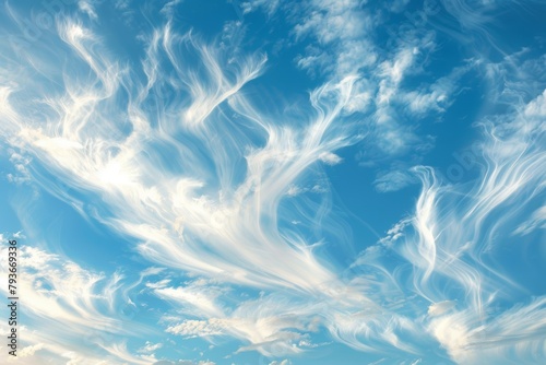 Wispy clouds floating peacefully against a backdrop of clear blue sky