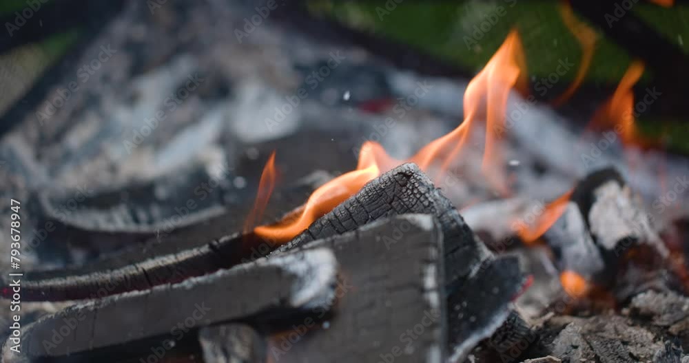 Macro close up of logs burning at the bottom of a fire pit in slow motion Macro close up of logs burning at the bottom of a fire pit in slow motion