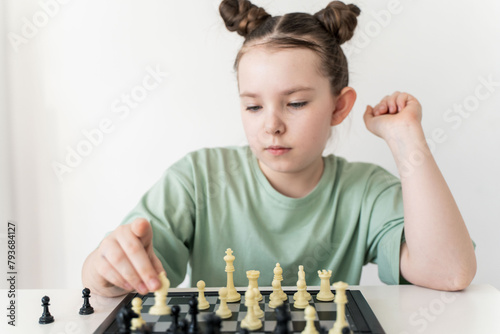 Little girl playing chess, focused look. Selected Focus