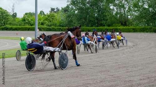 Foto Racing horses trots and rider on a track of stadium