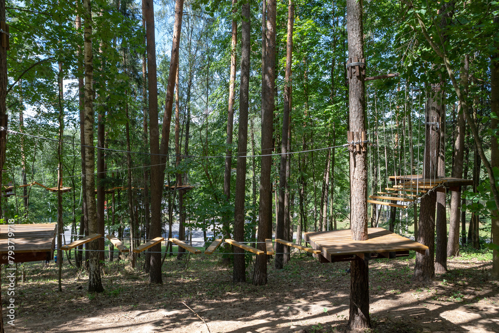 A rope town in a city park. High ropes experience adventure tree park. Rope road course in trees.