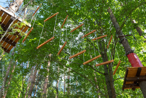 Adventure rope park. Wooden steps. High ropes experience adventure tree park. Rope road course in trees. 