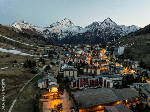 Town in the alps mountains during sunset.Aerial drone photo Blue Hour French alps in winter, Rhone Alpes in France Europe. Les deux alpes village in spring time.Winter French Alpes town from drone