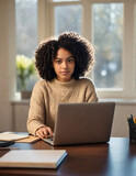 A-young-African-American-woman-with-curly-dark- hair working on laptop