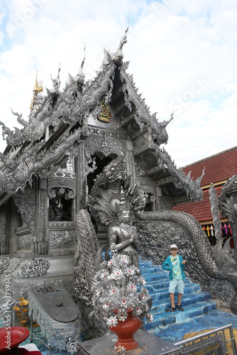 Tourist child, cute kid. Wat Sri Suphan Temple: Buddhist silver temple in Chiang Mai city, Thailand. Religious traditional national Thai architecture. Beautiful landmark, architectural monument