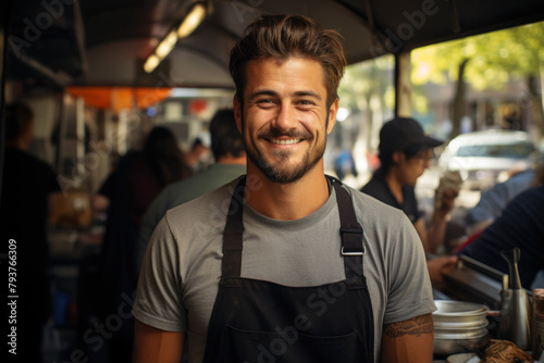 A friendly male employee in an apron in a street restaurant.