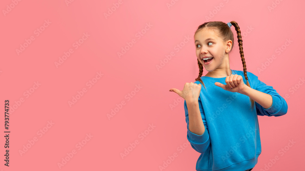 Smiling girl pointing thumbs at copy space Smiling girl pointing thumbs at copy space