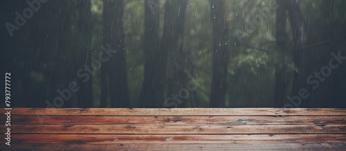 Wooden table close-up with rain shower in background