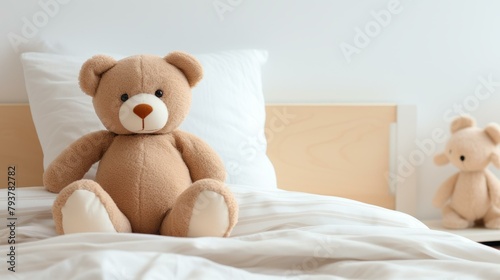 b'A cute teddy bear sitting on a bed with a white blanket'