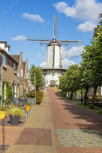 A sunny street in Willemstad with the Orangmolen, the local windmill, in the background