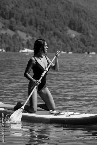 Summer vacation. Sexy woman paddling on paddle board or sup in lake. Summer lifestyle. Female fit spot model swimming with paddle board.