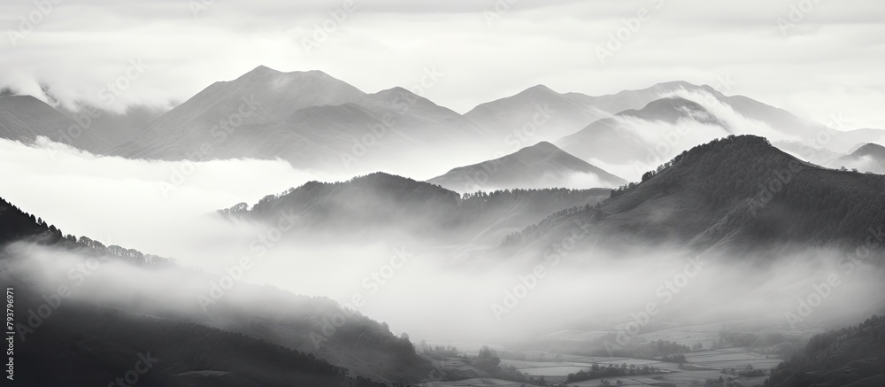 Mountains shrouded in mist and clouds in a valley Mountains shrouded in mist and clouds in a valley