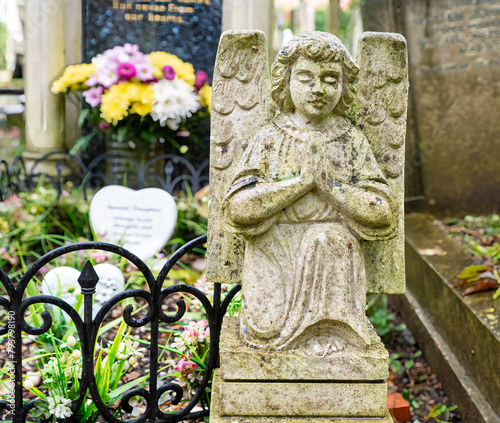 Kniender betender Engel und ein Blumenstrauß auf dem Highgate Cemetery Ostteil Camden, London