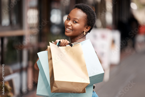 Smile, city and portrait of black woman with shopping bag for boutique deal, commerce and giveaway. Happy, person and customer with designer clothes for luxury discount, retail and sale in Nigeria photo