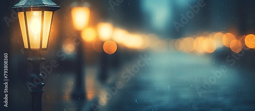 Car passing by a glowing streetlamp on a rainy evening photo