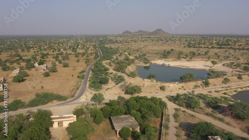 Road or sarak or sadak near a pond in a village at rajasthana. beautiful view of a village with road near a pond in a village of jodhpur district rajasthan. photo