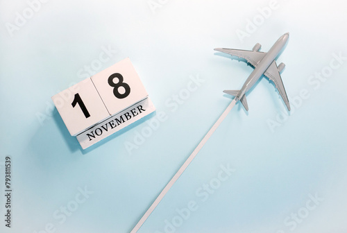 November calendar with number  18. Top view of a calendar with a flying passenger plane. Scheduler. Travel concept. Copy space.