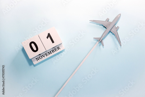 November calendar with number  1. Top view of a calendar with a flying passenger plane. Scheduler. Travel concept. Copy space.