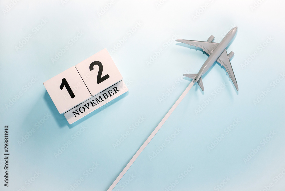 November calendar with number 12. Top view of a calendar with a flying passenger plane. Scheduler. Travel concept. Copy space. November calendar with number 12. Top view of a calendar with a flying passenger plane. Scheduler. Travel concept. Copy space.