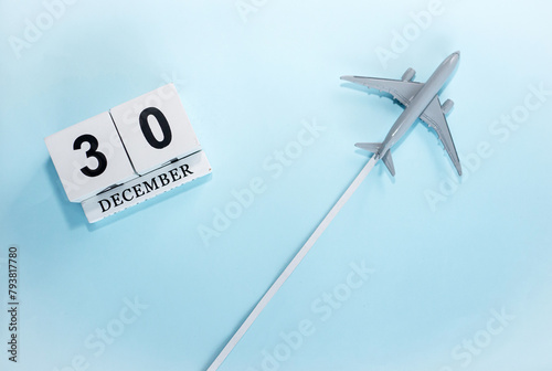 December calendar with number  30. Top view of a calendar with a flying passenger plane. Scheduler. Travel concept. Copy space.