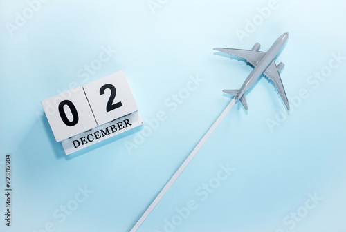 December calendar with number  2. Top view of a calendar with a flying passenger plane. Scheduler. Travel concept. Copy space.