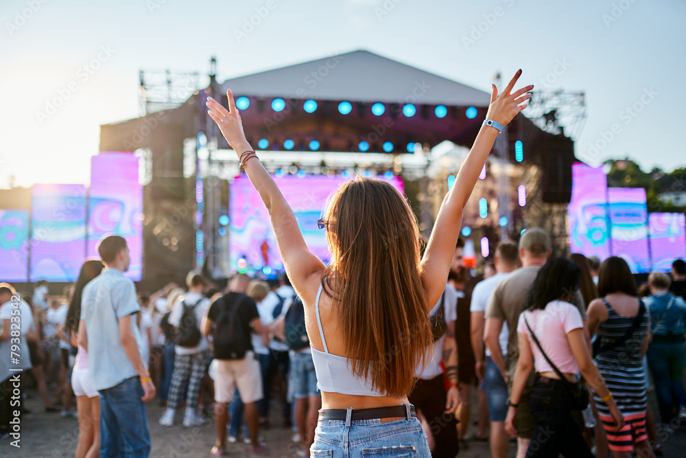 custom made wallpaper toronto digitalBack view of girl with raised arms, enjoying live music at sunset beach festival. Friends dance, celebrate in crowd, summer vibe at coastal event. Teens in casual wear, fun at sunny seaside gig.