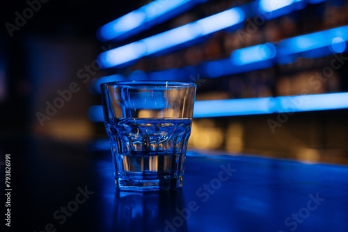 Tablou pe pânză A glass of water sits on a bar counter