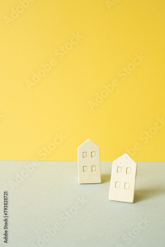 Obraz na płótnie Wooden house model on gray and yellow background. Real estate concept w salonie
