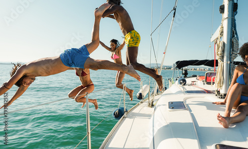 Multiracial frinds jumping inside the ocean during summer vacation - Holidays and travel concept - Main focus on left man body © DisobeyArt