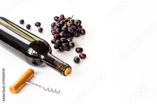 Bottle of wine with corkscrew and grapes. Wine background