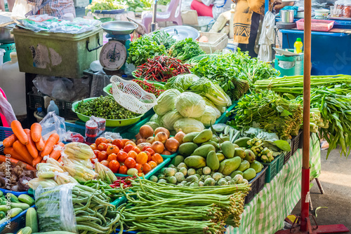 Variety of fresh vegetables are sold on the stalls for retail at the fresh food market.  Asparagus bean, onion, tomato, carrot, cucumber, pea eggplant, goat horn hot pepper, Thai green eggplant, etc. photo