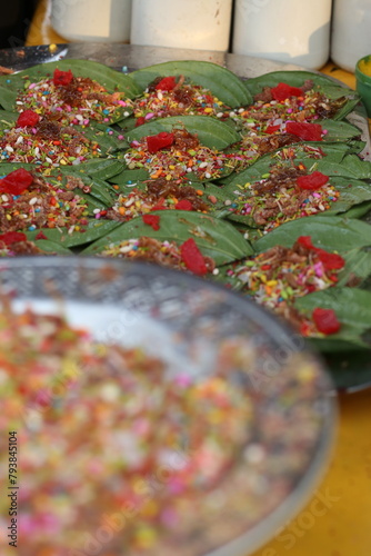 This is All testy sweet cherry metha khatta pan Nirmal, Banarasi paan or betel leaf garnished with betel nut and all indian colorful Banaras ingredients for sale at pous fair,
 photo