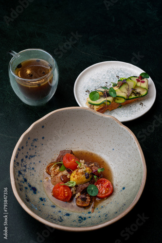 A rustic, but at the same time exquisite dish with juicy meat and bright cherry tomatoes combined with refreshing cucumber toasts. Rich tea completes the culinary experience. (ID: 793847336)