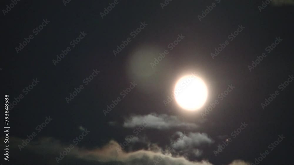 Dark night sky with moving clouds and emerging light of full moon and starlight - timelapse. Topics: weather, meteorology, astronomy, space Dark night sky with moving clouds and emerging light of full moon and starlight - timelapse. Topics: weather, meteorology, astronomy, space