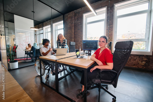 A diverse group of business professionals collaborates in a modern startup coworking center, utilizing a mix of paper-based and technological tools such as mobile phones and computers 