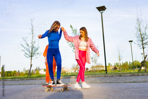 Ragazze in città che si divertono correndo sullo skateboard. photo