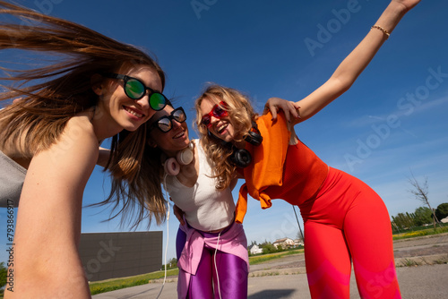 tre ragazze felici che ascoltano musica in esterna photo