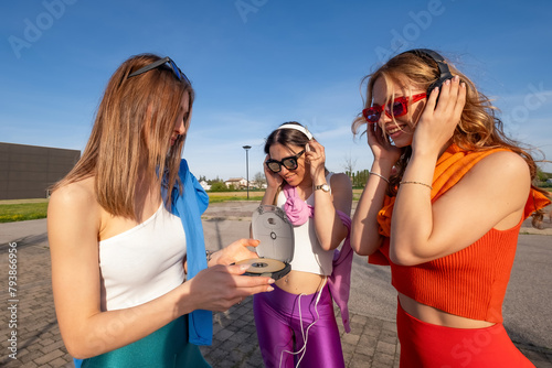 tre ragazze felici che ascoltano musica in esterna photo