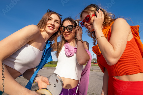 tre ragazze felici che ascoltano musica in esterna photo